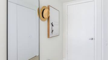Un corridoio con uno specchio grande, una porta e un quadro appeso al muro.