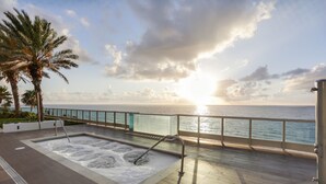 A spa area with a hot tub, a glass railing, and a view of the sea. - Monte Carlo by Miami Vacations (Miami Beach)
