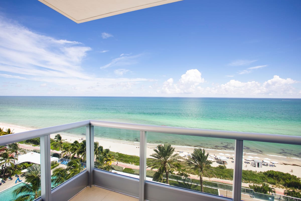 A balcony with a view of a beach and ocean.