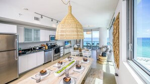A modern kitchen with a large island, stainless steel appliances, and a view of the ocean. - Monte Carlo by Miami Vacations (Miami Beach)