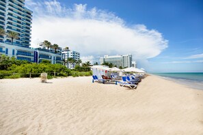 On the beach, white sand, sun loungers, beach umbrellas