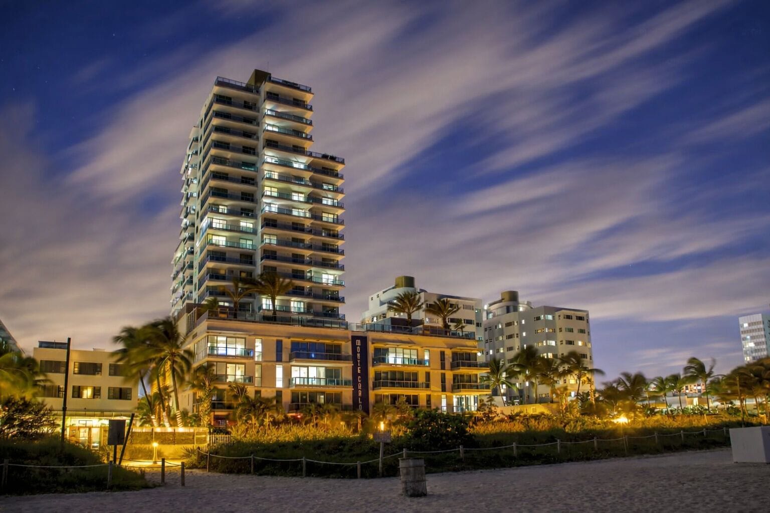 Un hotel de gran altura con múltiples pisos, balcones y una fachada bien iluminada.