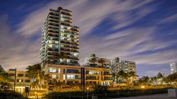 Un hotel de gran altura con múltiples pisos, balcones y una fachada bien iluminada.