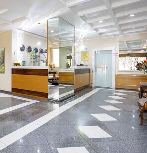 A reception area with a modern design, featuring a reception desk, a glass partition, and a patterned floor. - Park Tower Campinas by Nacional Inn (Campinas)