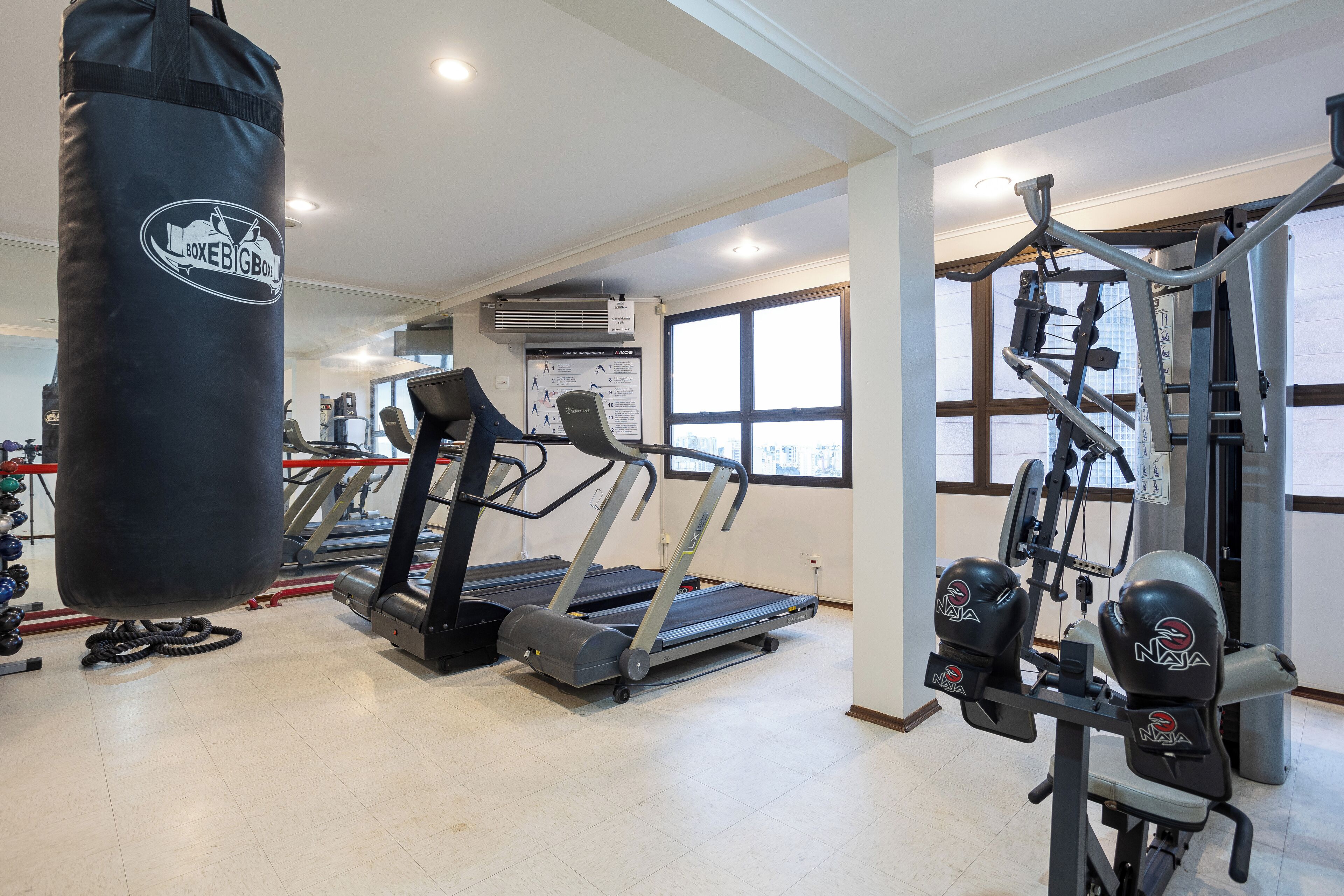A gym with treadmills, a punching bag, and weight machines.