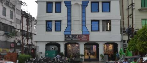 Un edificio de varios pisos con un llamativo letrero que dice 'Hotel Bliss'.