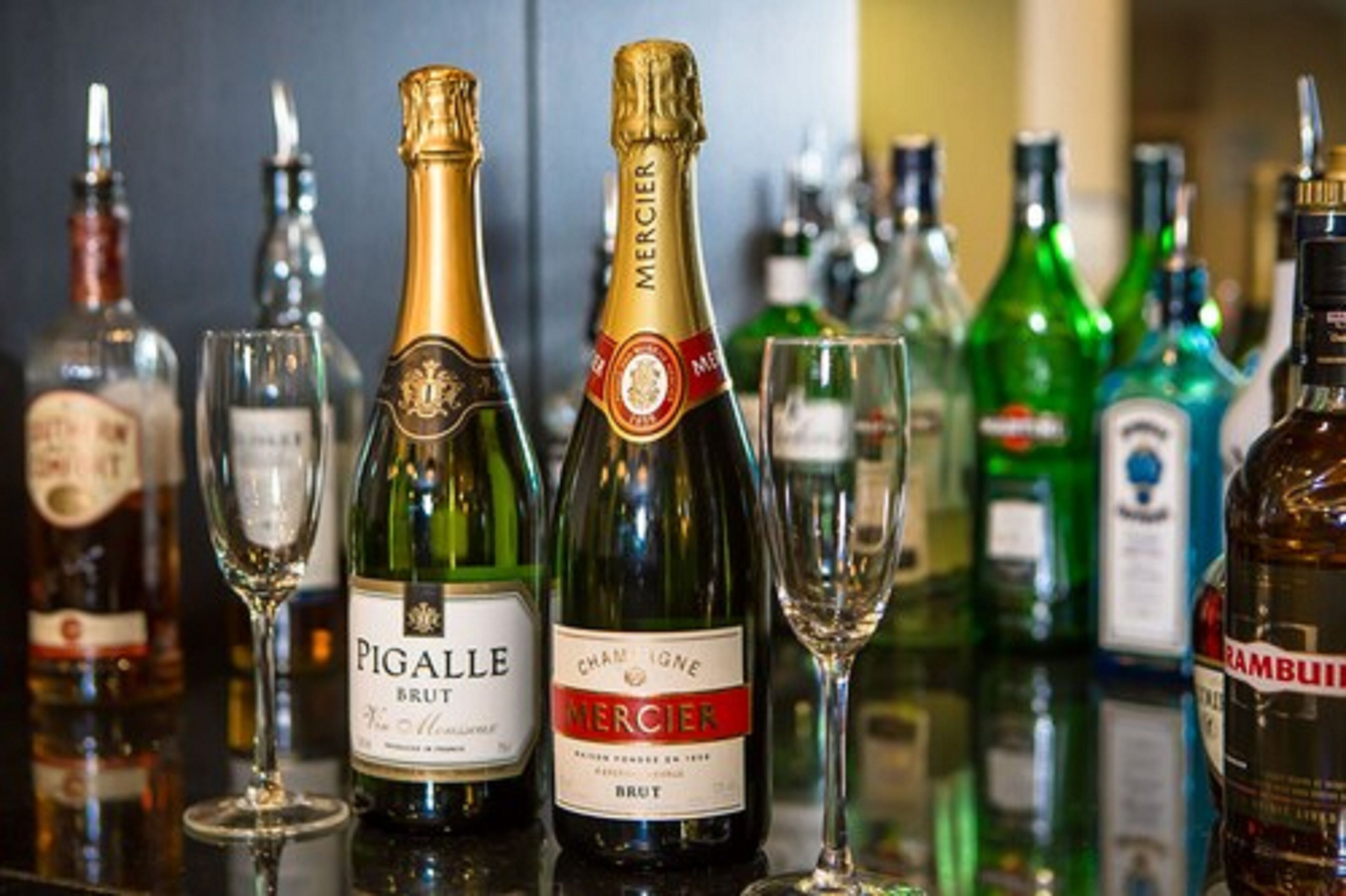 Un bar con varias botellas de alcohol y vasos.