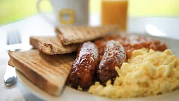 Un plato con tostadas, salchichas y huevos revueltos.