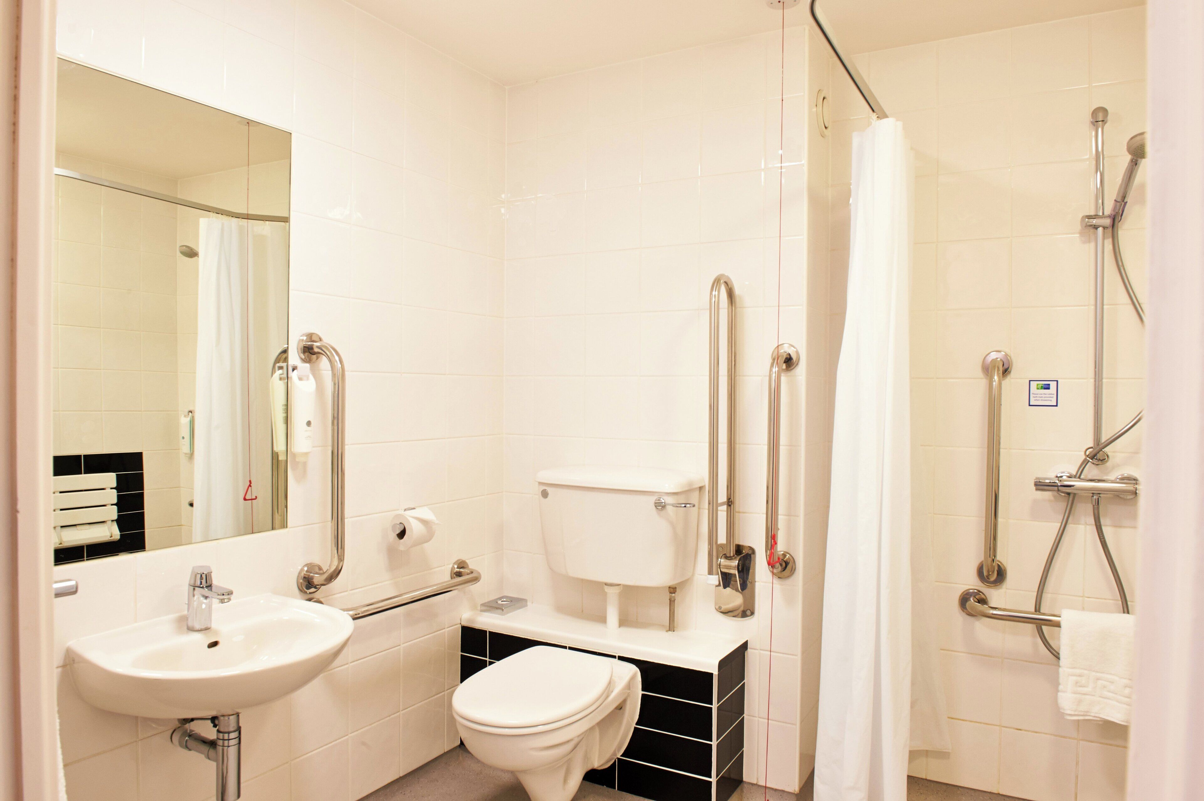 Un baño con lavamanos, inodoro y zona de ducha.