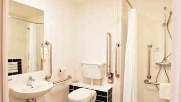 Un baño con lavamanos, inodoro y zona de ducha.