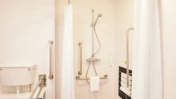 Een moderne badkamer met een inloopdouche, handgrepen, een toilet met een veiligheidsbeugel en een handdoekhouder.