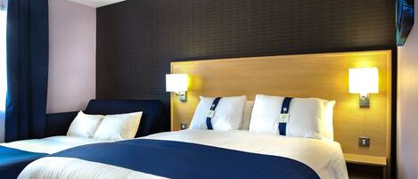 Een hotelkamer met twee bedden, een donkere muur en twee wandlampen.