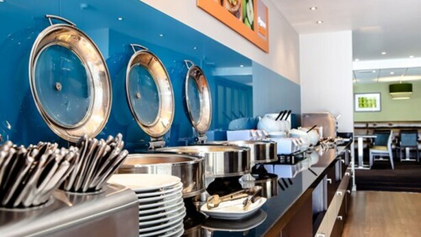 A buffet setup with multiple serving stations, including large metal serving bowls and utensils. - Holiday Inn Express Manchester Airport by IHG (Manchester)