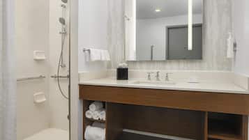 Un baño moderno con ducha, lavabo y espejo.