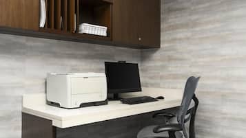 Un bureau moderne, équipé d’une imprimante, d’un écran, d’un clavier et d’une chaise de bureau.