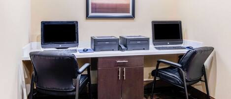 A workspace with two laptops, two printers, and two chairs.