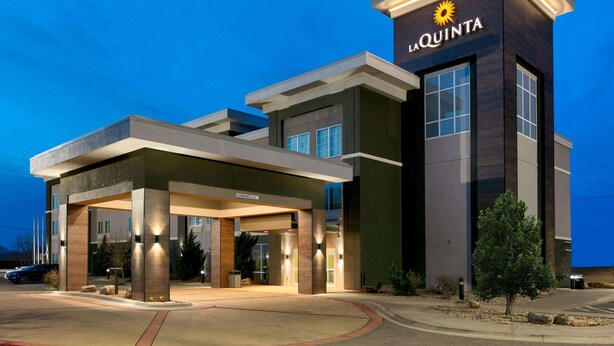 Une entrée d’hôtel moderne, avec une enseigne bien visible portant l’inscription « LA QUINTA ».
