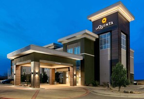Una entrada de hotel moderna con un cartel llamativo que dice "LA QUINTA".