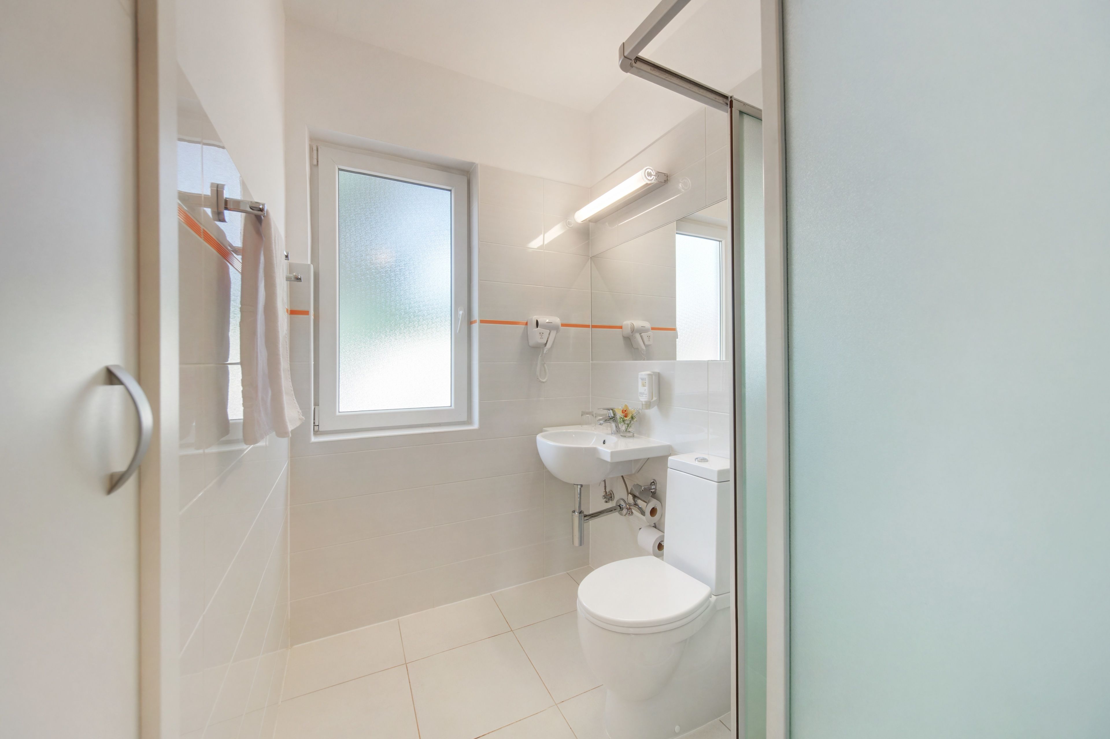 A modern bathroom with a toilet, sink, and shower area.