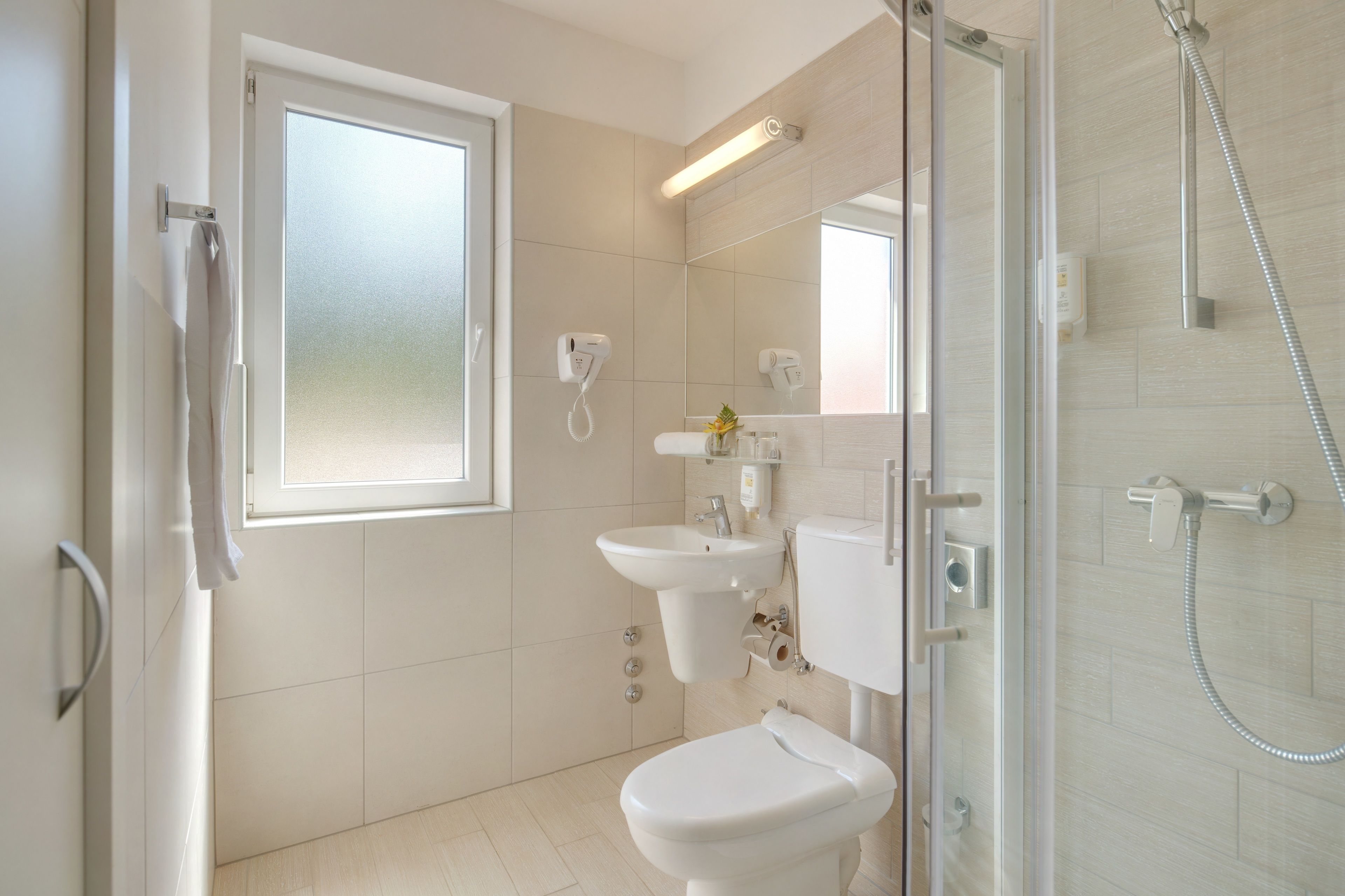 Ein modernes Badezimmer mit Toilette, Waschbecken und Dusche.