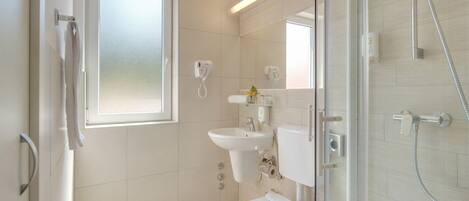 Ein modernes Badezimmer mit Toilette, Waschbecken und Dusche.