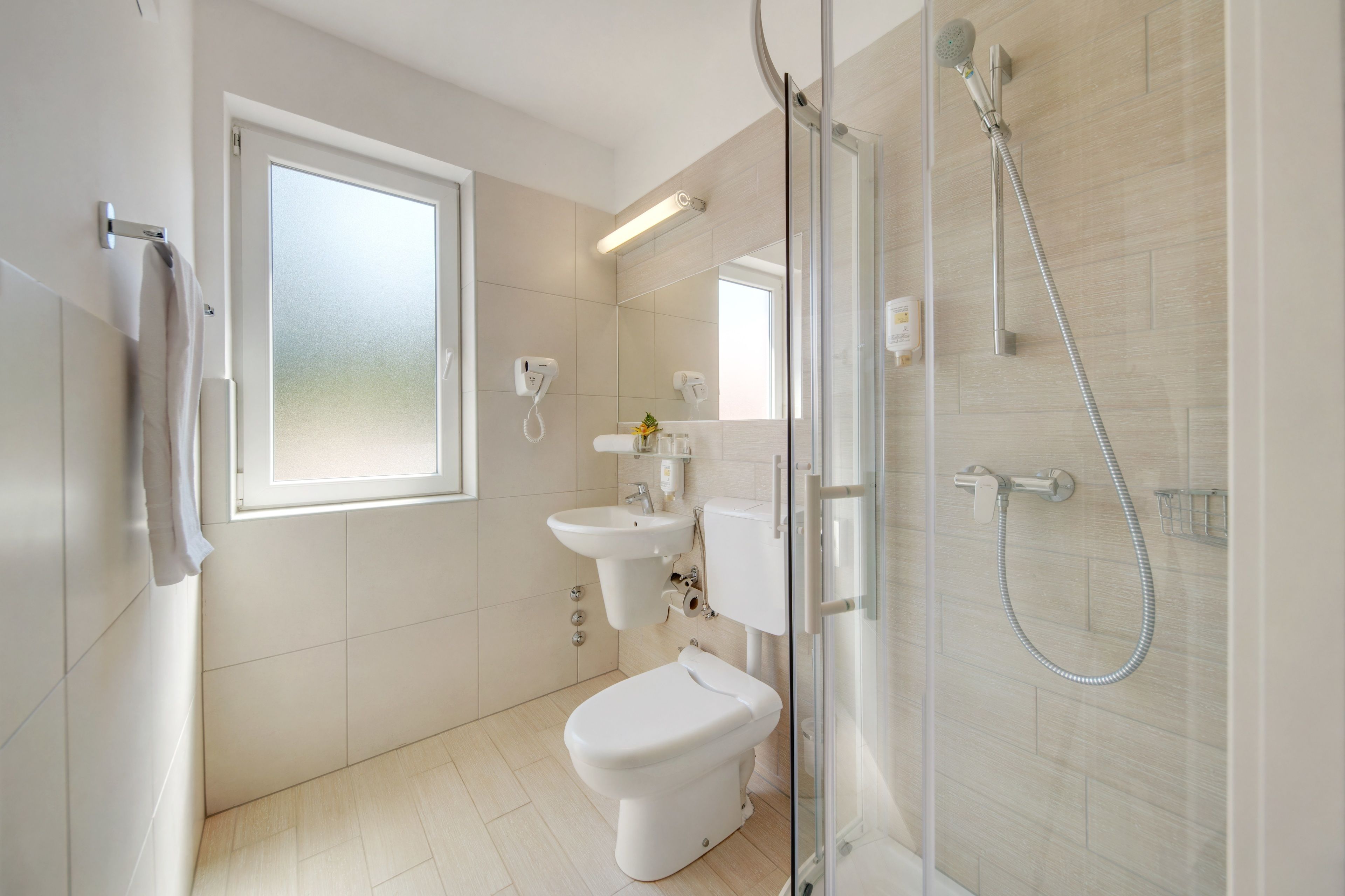 A modern bathroom with a toilet, sink, and shower.