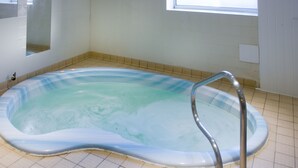 A hot tub in a bathroom with tiled flooring and a window above it. - New Westcliff Hotel (Bournemouth)