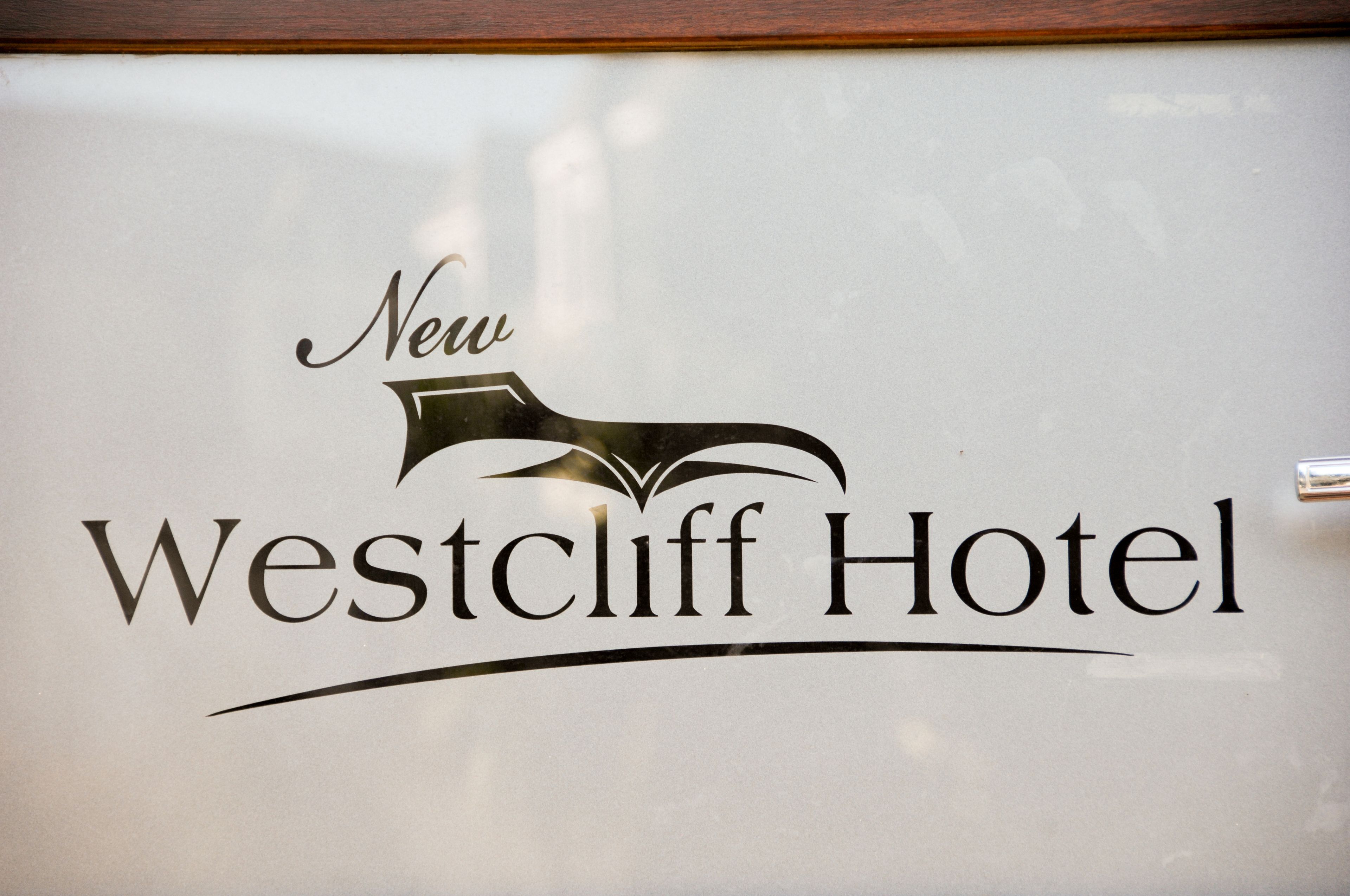 A hotel sign with the name "New Westcliff Hotel" and a stylized bird logo.