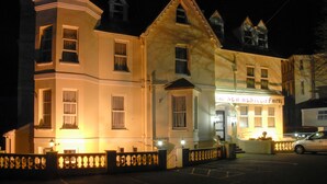 A hotel with a classic architectural style, featuring a prominent entrance and a well-lit facade. - New Westcliff Hotel (Bournemouth)