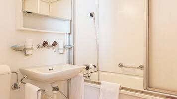 A bathroom with a toilet, sink, and shower.