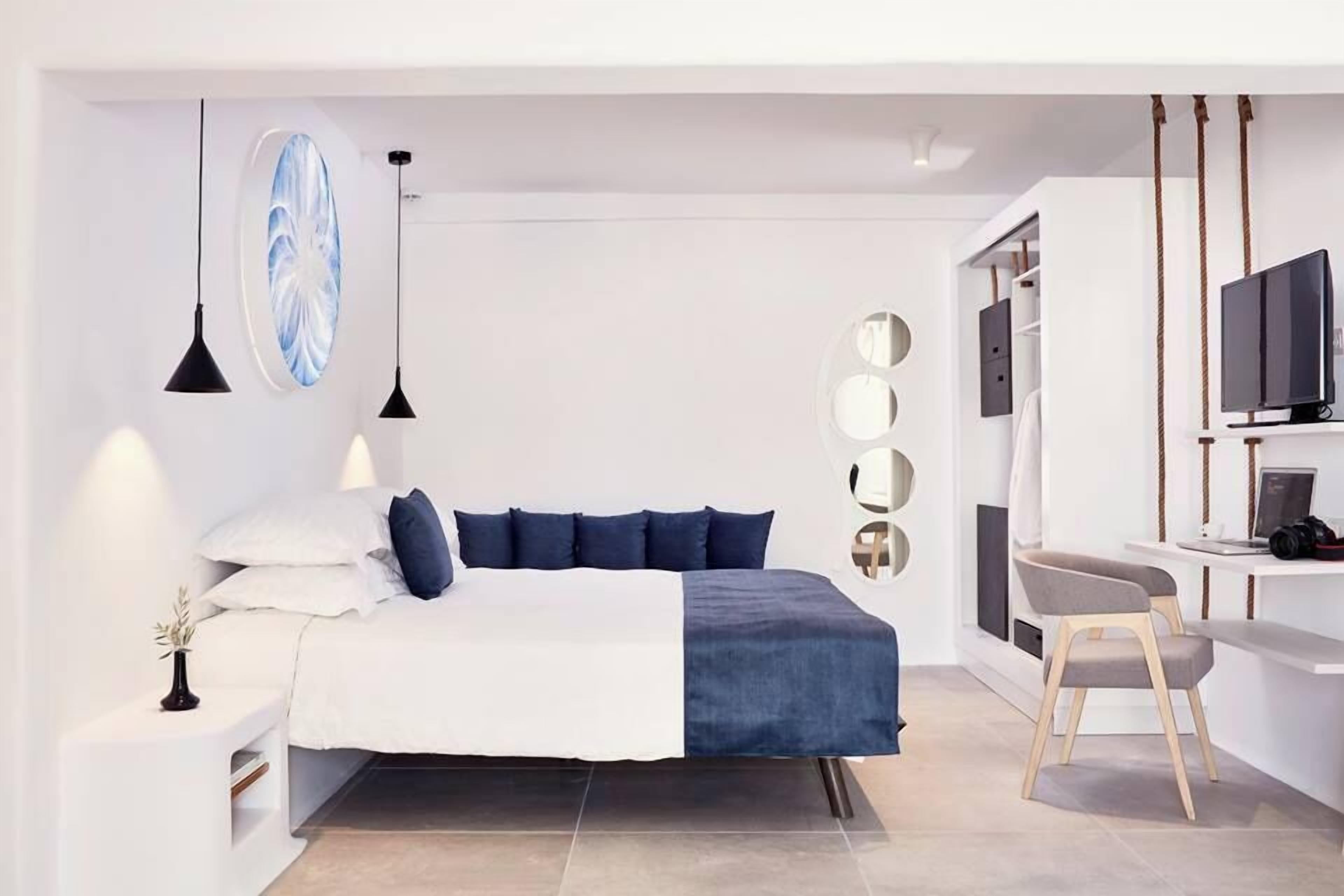 A modern bedroom with a bed, bedside table, and a desk area with a chair.