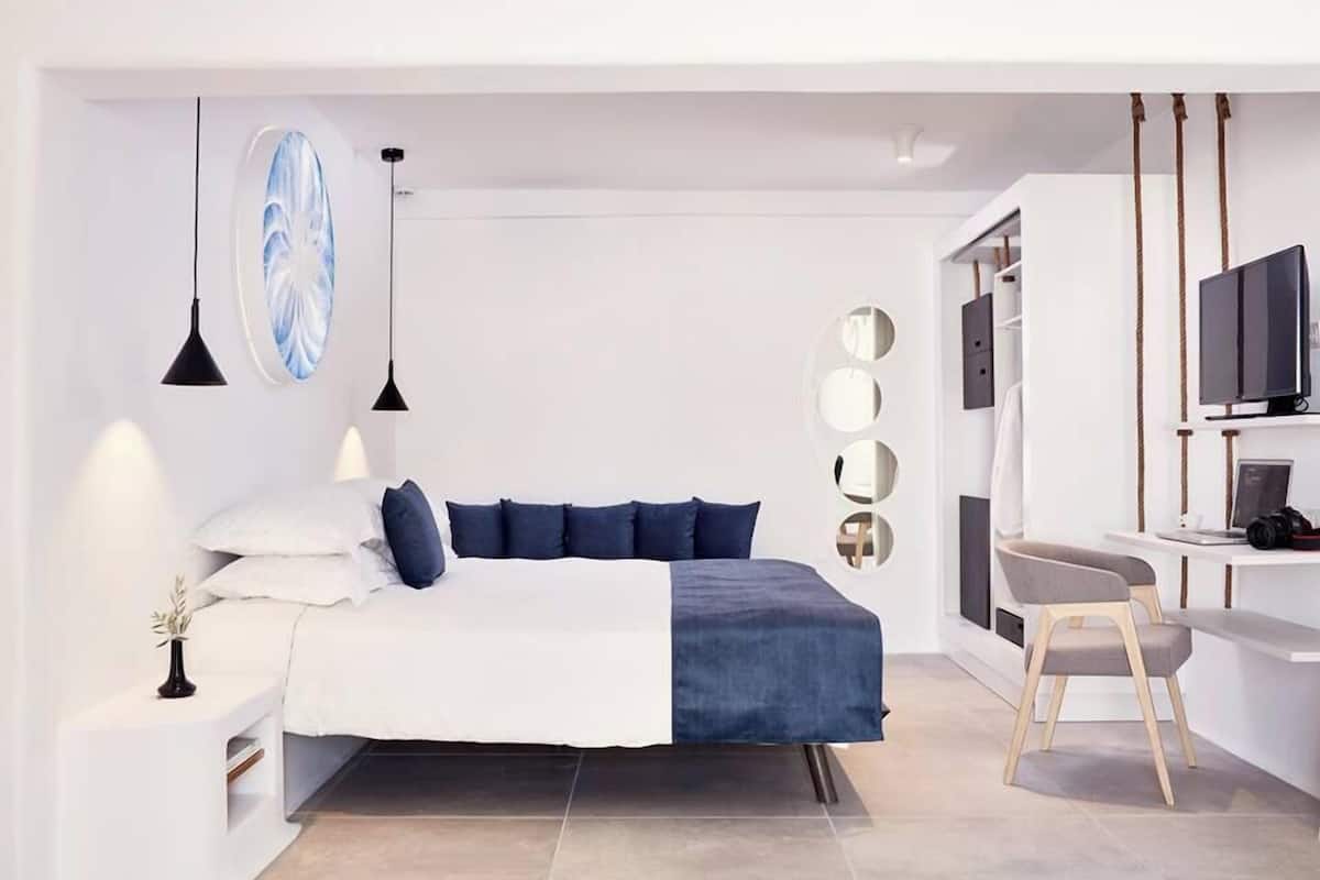 Une chambre moderne comprenant un lit, une table de chevet et un espace bureau avec une chaise.