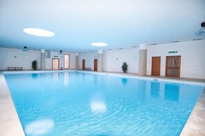 Piscine couverte, piscine extérieure, parasols de plage, chaises longues