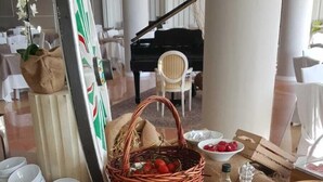 Un bufé de desayuno con diversas opciones de comida y un piano al fondo.