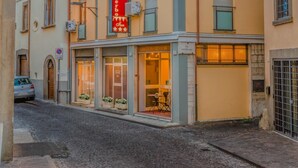 Un hotel de varios pisos con balcones, unidades de aire acondicionado y un letrero rojo que indica que es un hotel.