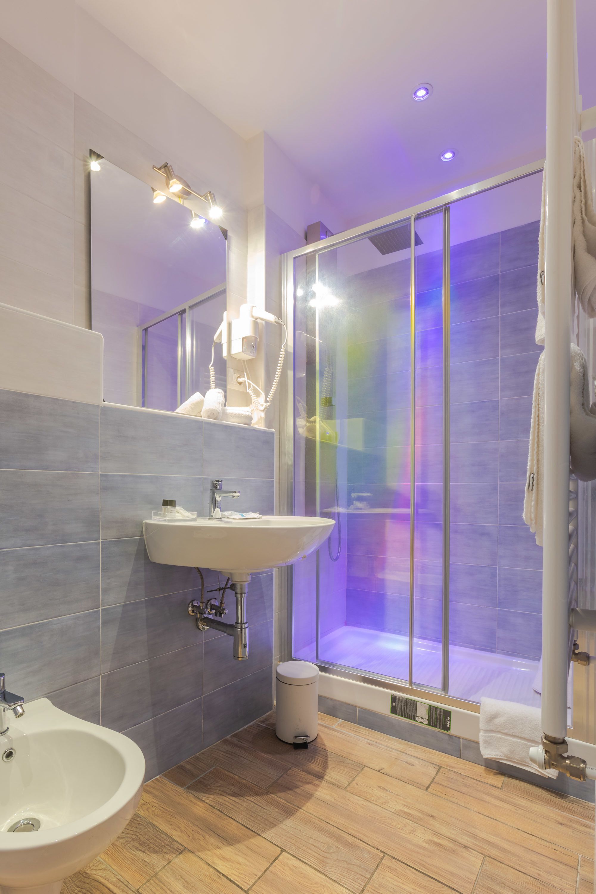 Ein modernes Badezimmer mit einer Duschkabine, einem Waschbecken und einem Spiegel.