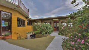A yellow building with a covered patio and a restaurant sign. - Hotel Don Taco (Monteverde)