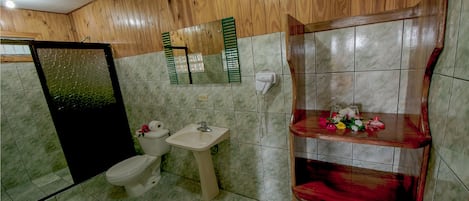 A bathroom with a wooden vanity, a toilet, and a sink.