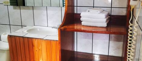 A bathroom with a wooden vanity, a towel rack, and a telephone.