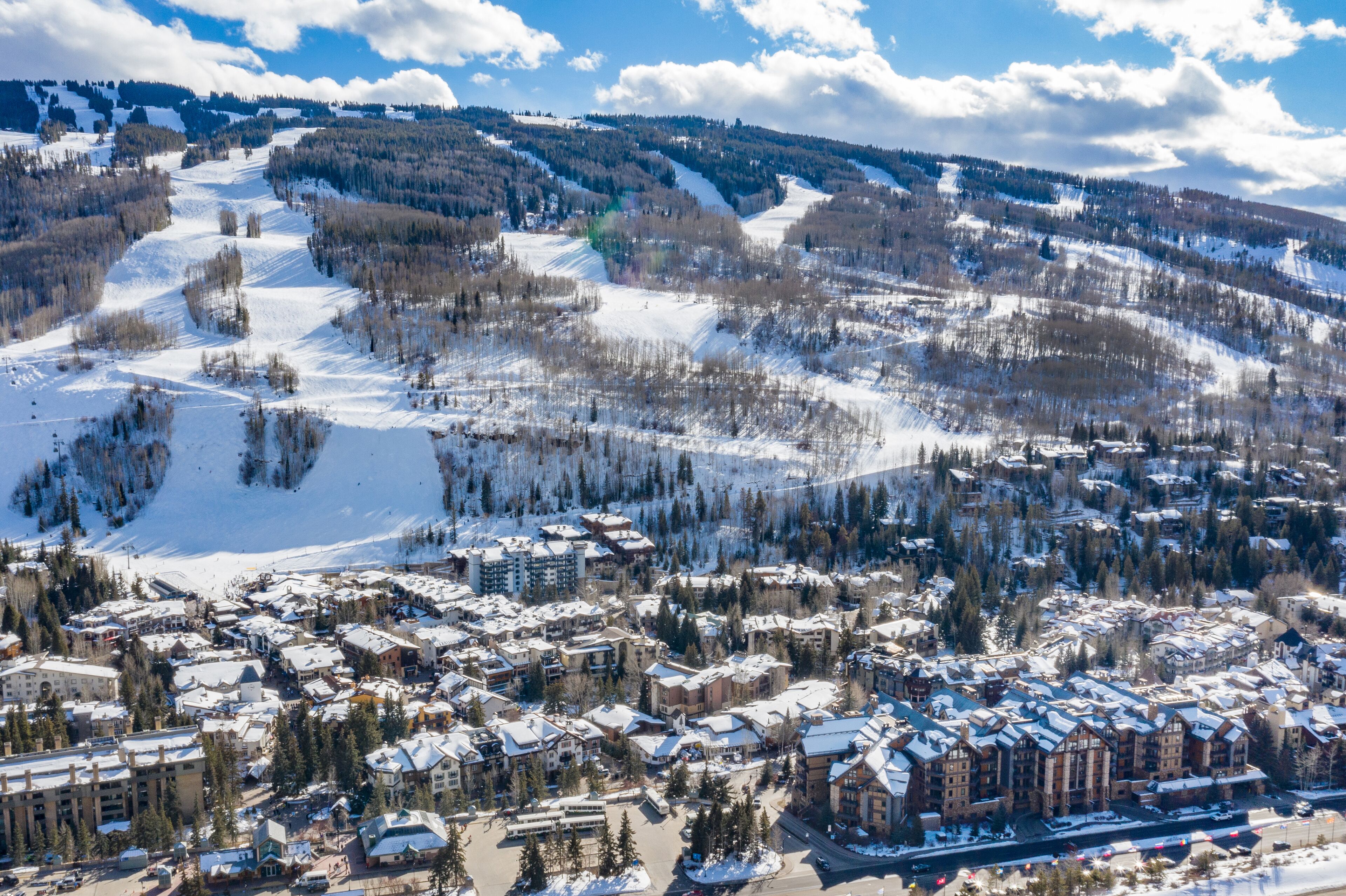A snow-covered mountain town with buildings, roads, and ski slopes.