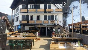 Un edificio de varios pisos con un telesilla y un área de estar al aire libre.