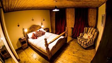 Una habitación con una cama de madera, una silla y techo de madera.