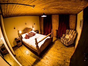 A room with a wooden bed, a chair, and a wooden ceiling. - Inferno Morzine (Morzine)