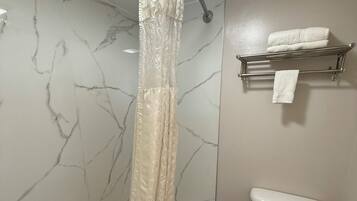 A bathroom with a bathtub, toilet, and towel rack.