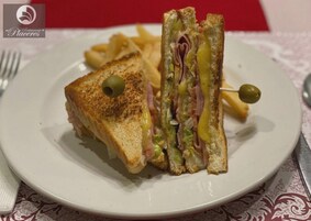 Un plato con un sándwich a la plancha y papas fritas.