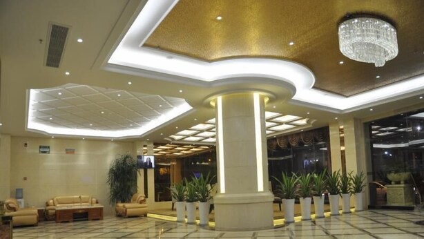 A spacious lobby with a polished marble floor, a central column, and a chandelier. - GreenTree Inn Shantou Chengjiang Road Business Hotel (Shantou)