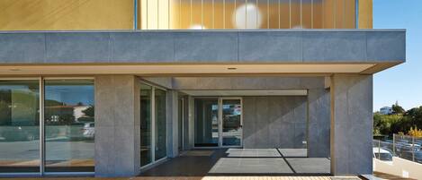 A modern hotel with a prominent "HOTEL" sign, large glass windows, and a clean, contemporary design.