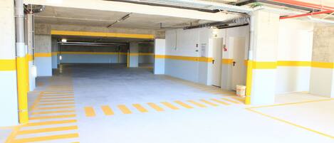 An empty parking garage with yellow and white painted lines and walls.