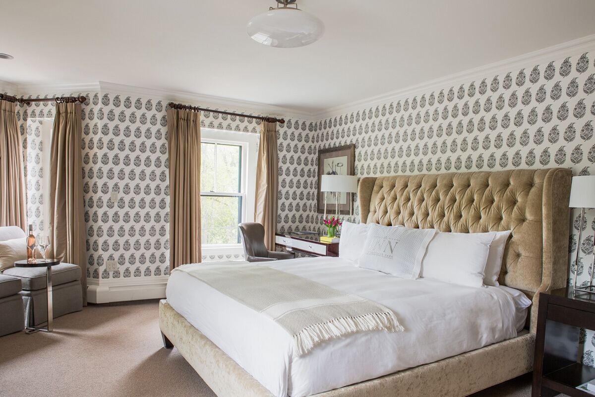 A well-appointed bedroom with a large bed, a desk, and a chair.