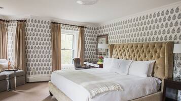 A well-appointed bedroom with a large bed, a desk, and a chair.